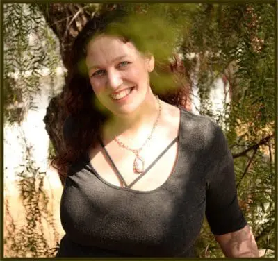 Katie Weatherup smiling through a pepper tree.