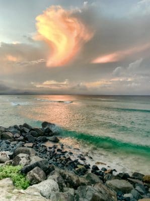 Sunset over ocean with clouds that look like a flame