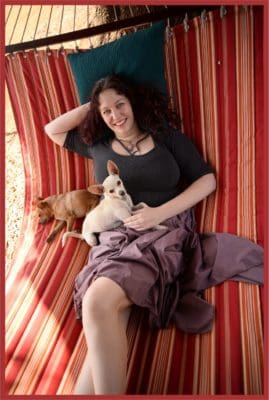 Katie Weatherup reclining in hammock small with dogs to illustrate value of of power animals connections.