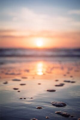 beach at sunset with rocks on beach and reflections. Sooth your anxiety. 